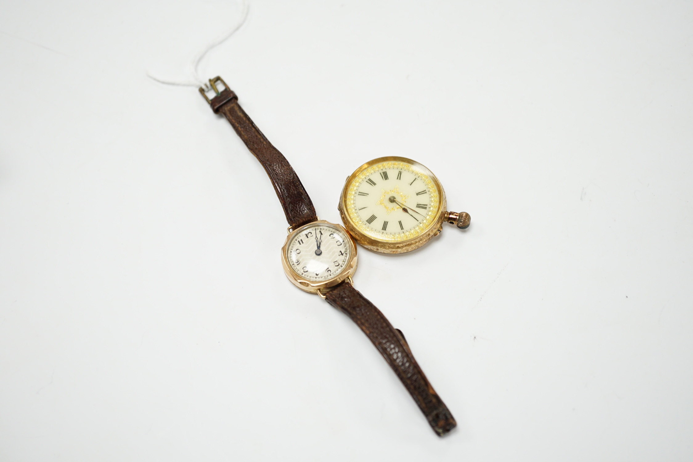 A 14k open faced keyless fob watch, with Roman dial, gross weight 31.7 grams and a lady's 9ct gold manual wind wrist watch (lacking winding crown), on a leather strap.